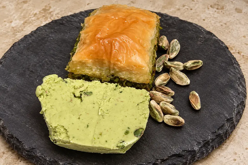Koyu taş üzerinde baklava ve yanında fıstıklı dondurma; sunum önerisi.